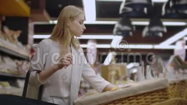 销售，购物，消费主义和人的概念-幸福的年轻女人选择和阅读标签上的面包在市场上。